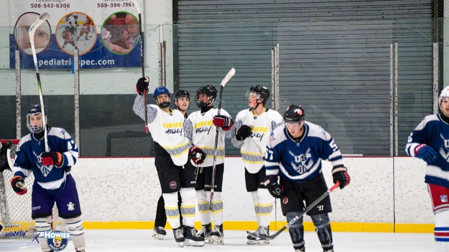 Corners Hockey players celebrating along the boards